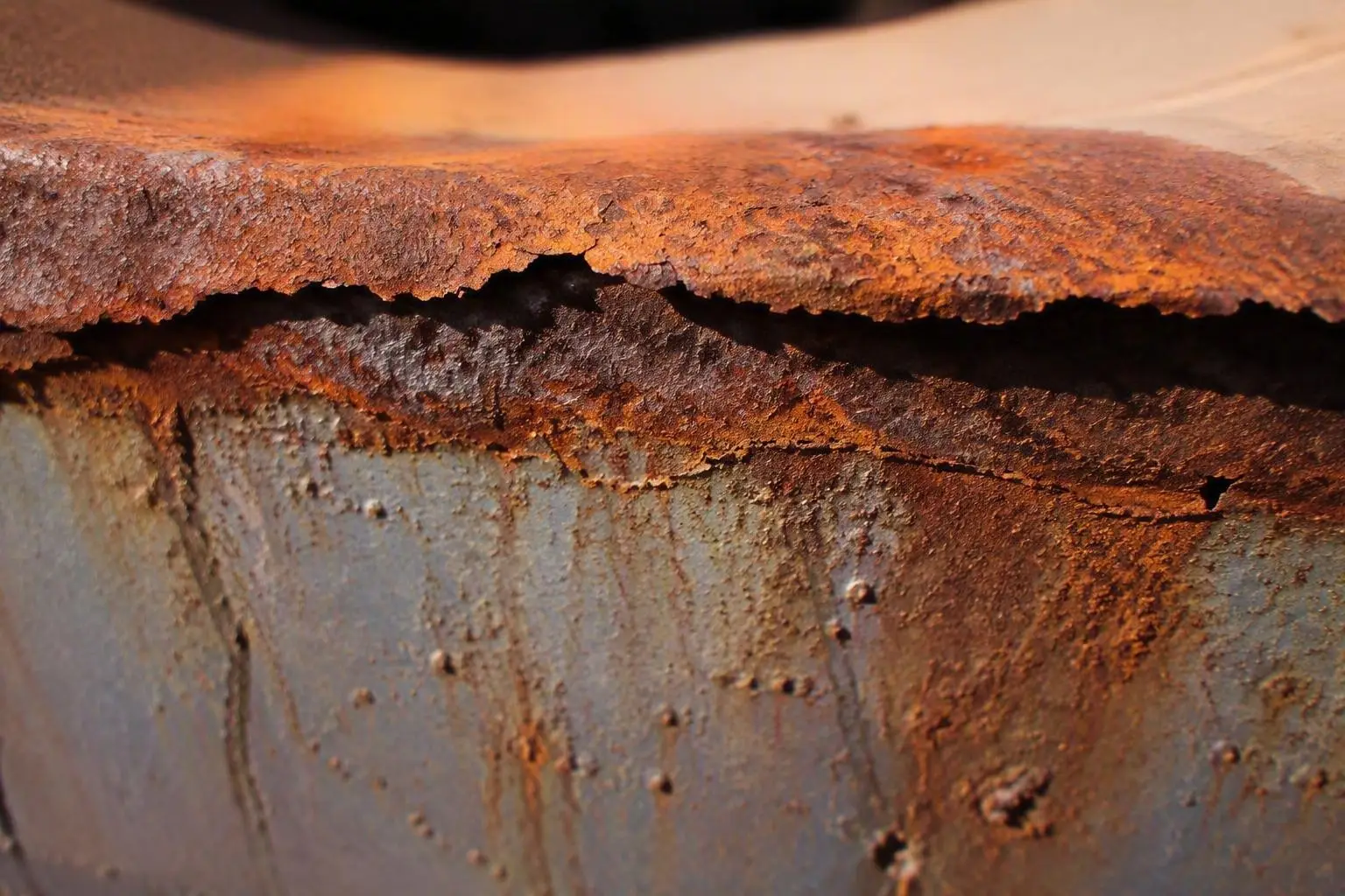Corroded metal surface with visible rust damage, representing corrosion environments encountered by products in service.