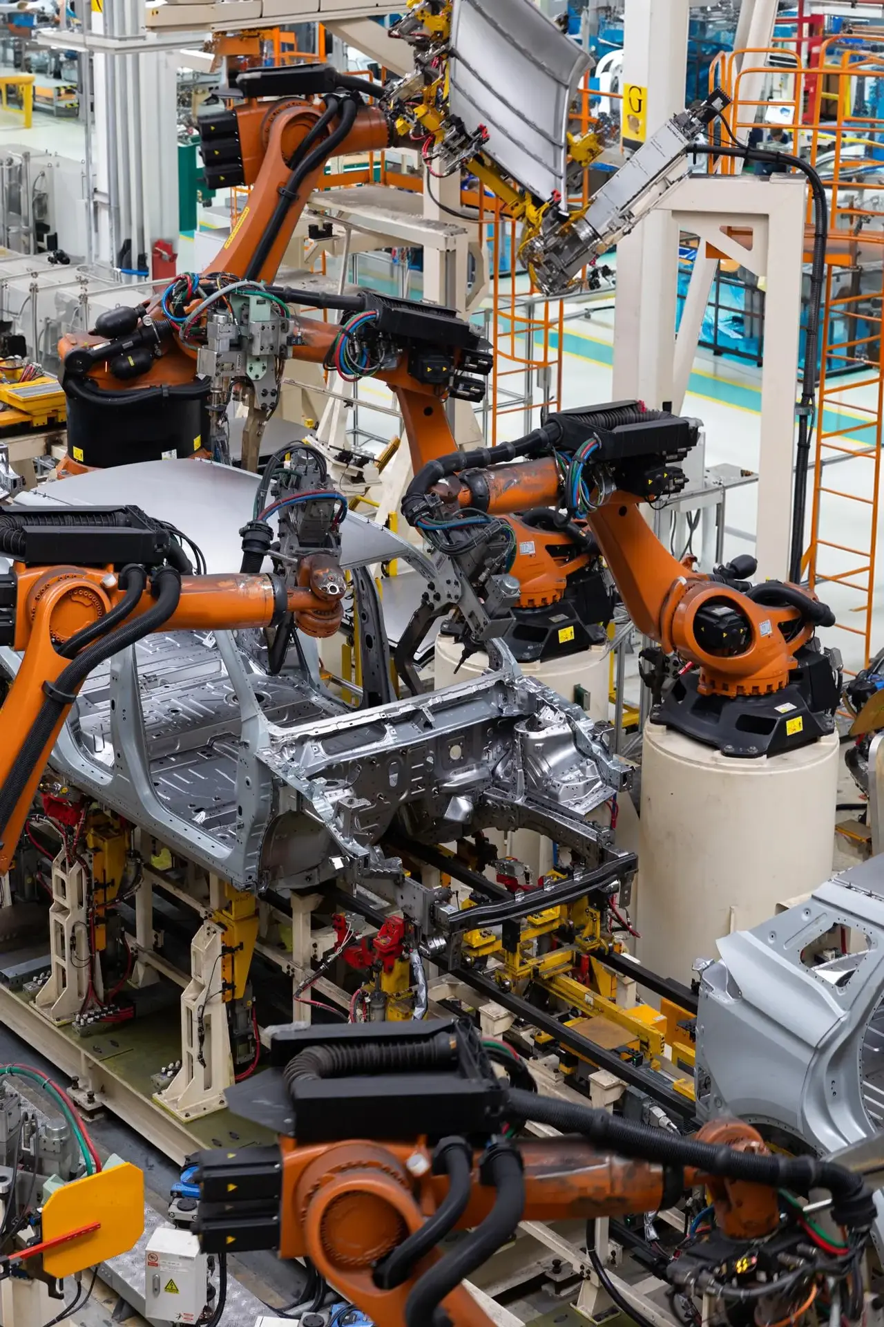 Automated vehicle assembly line with robotic manufacturing systems